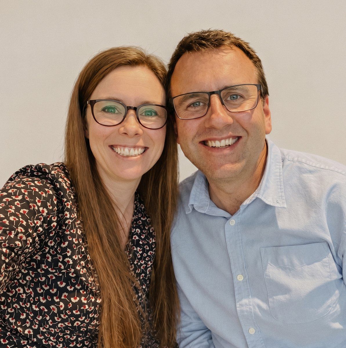 Kate and her husband Daniel side by side, both in glasses, smiling at the camera.