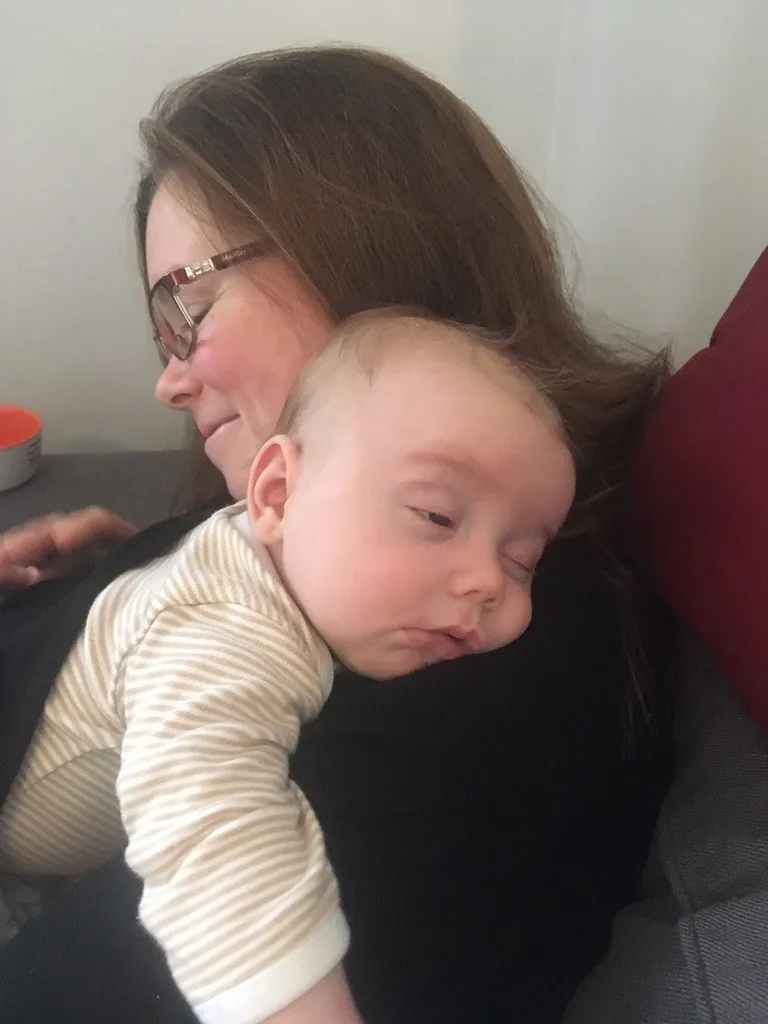 Kate, years ago, with one of her children asleep on her shoulder.