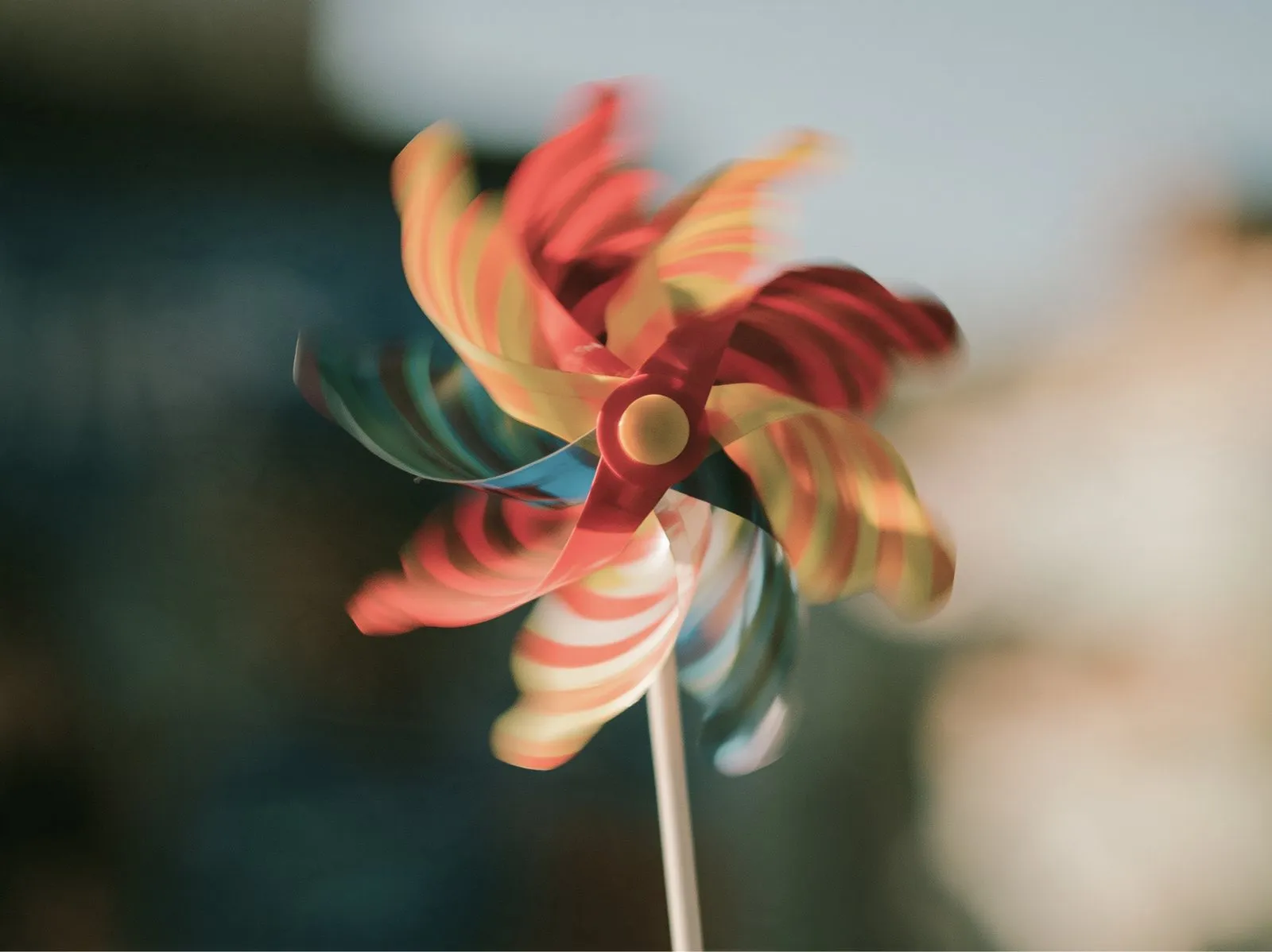 A red and cream pinwheel turning in soft light.